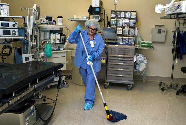 Zana Oprescu cleans an operating room as an environmental services aide at Sunrise Hospital on Tuesday, August 12, 2014.