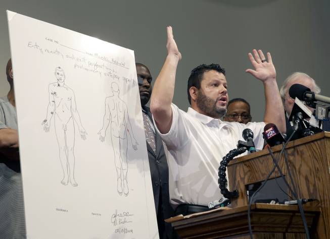 Forensic pathologist Shawn Parcells speaks during a news conference to share preliminary results of a second autopsy done on Michael Brown Monday, Aug. 18, 2014, in St. Louis County, Mo. The independent autopsy shows 18-year-old Michael Brown was shot at least six times, and Parcells, who assisted former New York City chief medical examiner Dr. Michael Baden during the autopsy, said a graze wound on Brown's right arm could have occurred in several ways. 
