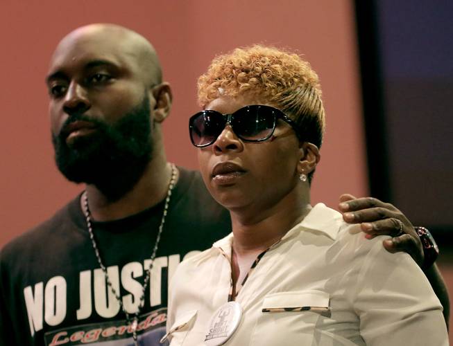 Parents of Michael Brown, Michael Brown Sr. and Lesley McSpadden, listen to a speaker during a rally, Sunday, Aug. 17, 2014, for their son who was killed by police last Saturday in Ferguson, Mo.