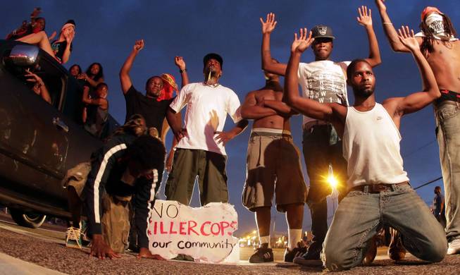 People protest Sunday, Aug. 17, 2014, for Michael Brown, who was killed by a police officer last Saturday in Ferguson, Mo.