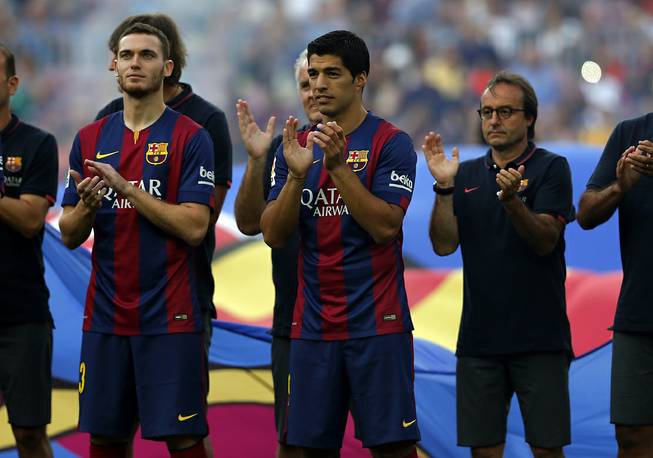 Barcelona's Luis Suarez, from Uruguay, center, reacts during the official presentation of the Barcelona F.C. team for the season 2014-15 ahead of the Joan Gamper trophy match at the Camp Nou in Barcelona, Spain, Monday, Aug. 18, 2014.