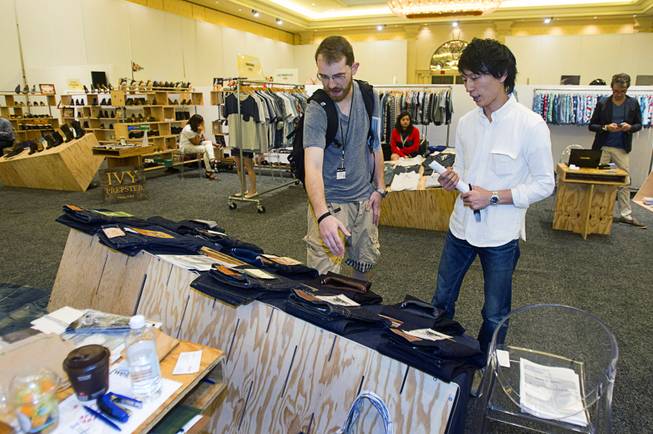 Sean Barry, left, of New York looks over Momotaro (Peach Boy) Jeans with Tabuchi Tatsushi during the Modern Assembly fashion trade show at the Sands Expo & Convention Center Wednesday, Aug. 20, 2014. Barry said Japanese jeans age in unique ways reflecting their wearer's usage. The jeans take their name from a popular Japanese folktale because  the folktale is believed to have originated in Okayama, Japan where the company is based. The show is a collection of six shows: The Accessories Show, Agenda, Capsule, Liberty, Mrket, and Stitch.
