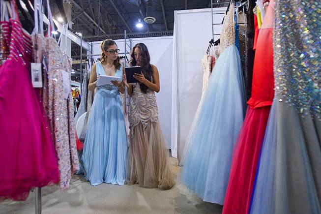 Models Jordan Lopez, left, and Arianna Colffer help with inventory in the Terani Couture booth at the conclusion of the Modern Assembly fashion trade show at the Sands Expo & Convention Center Wednesday, Aug. 20, 2014. The show is a collection of six shows: The Accessories Show, Agenda, Capsule, Liberty, Mrket, and Stitch.