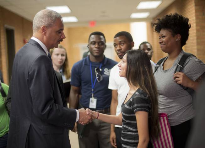 Attorney General Eric Holder shakes hands with Bri Ehsan, 25, right, following his meeting with students at St. Louis Community College Florissant Valley in Ferguson, Mo., Wednesday, Aug. 20, 2014.