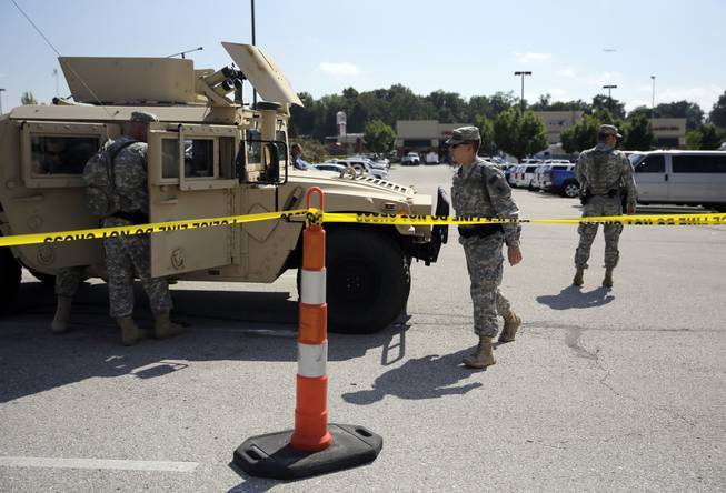 Members of the Missouri National Guard secure the perimeter of a police command post Tuesday, Aug. 19, 2014, in Ferguson, Mo. 