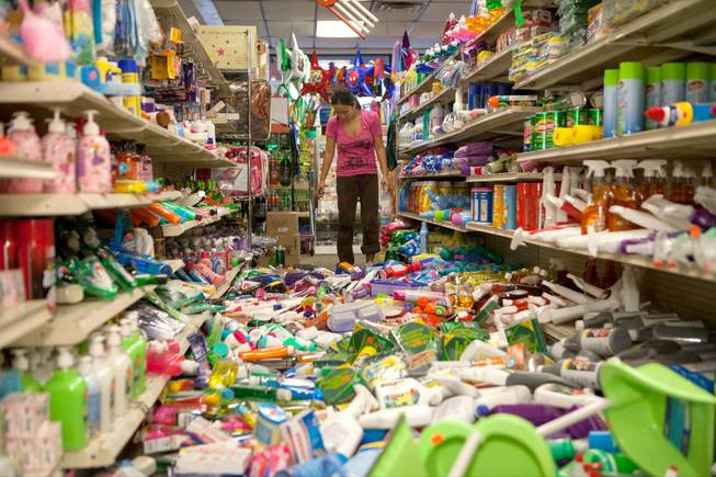 Nina Quidit cleans up the Dollar Plus and Party Supplies Store in American Canyon Calif. after an earthquake on Sunday Aug. 24, 2014. Quidit and her husband were woken up in the early morning hours by the store's alarm company and immediately drove in to begin clean up. The 6.0-magnitude quake caused six significant fires, including at four mobile homes, Napa Division Fire Chief Darren Drake said.