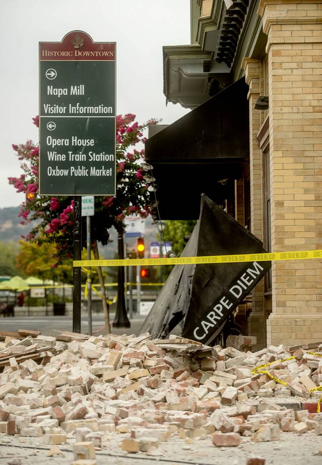 An awning for Carpe Diem wine bar sits among rubble in Napa, Calif., following an earthquake Sunday, Aug. 24, 2014. A large earthquake caused significant damage and left at least three critically injured in California's northern Bay Area early Sunday, igniting fires, sending at least 87 people to a hospital, knocking out power to tens of thousands and sending residents running out of their homes in the darkness.