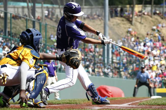South Korea’s Jae Yeong Hwang hits an RBI-double off Chicago’s Brandon Green during the first inning of the championship baseball game at the Little League World Series, Sunday, Aug. 24, 2014, in South Williamsport, Pa. Chicago catcher Joshua Houston, left, looks on. South Korea won 8-4.