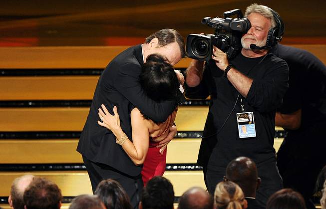 Bryan Cranston kisses Julia Louis-Dreyfus as she accepts the award for outstanding lead actress in a comedy series for her work on “Veep” at the 66th Annual Primetime Emmy Awards at Nokia Theatre L.A. Live on Monday, Aug. 25, 2014, in Los Angeles.