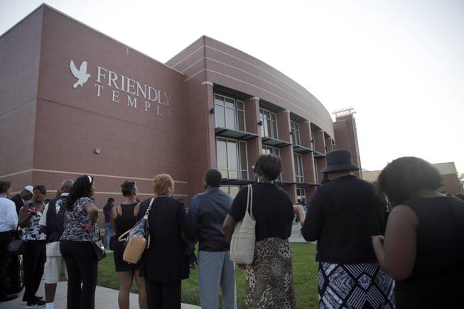 People begin to line up for the funeral of Michael Brown, Monday, Aug. 25, 2014, in St. Louis. Brown, who is black, was unarmed when he was shot Aug. 9, by Officer Darren Wilson, who is white. A grand jury is considering evidence in the case and a federal investigation is also underway.