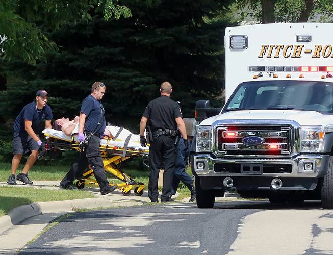 In this Aug. 22, 2014 photo emergency personnel transport Andy Steele, a recently retired Dane County sheriff's deputy, from his hom in Fitchburg, Wis. Authorities said Steele, 39, has been arrested in the fatal shooting of his wife, Ashlee Steele, 39, and sister-in-law, Kacee Tollesfsbol, 38, who were found shot dead in the Steele home.