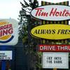 A Burger King sign and a Tim Hortons sign are displayed on St. Laurent Boulevard in Ottawa, Canada, on Monday, Aug. 25, 2014.