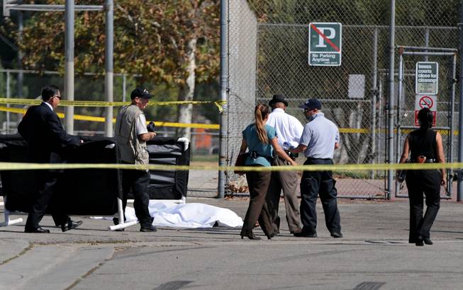 Los Angeles Police Department officers investigate the scene of a shooting Sunday, Aug. 24, 2014, where one person was killed near the 14400 block of Polk Street in Sylmar, Calif. 