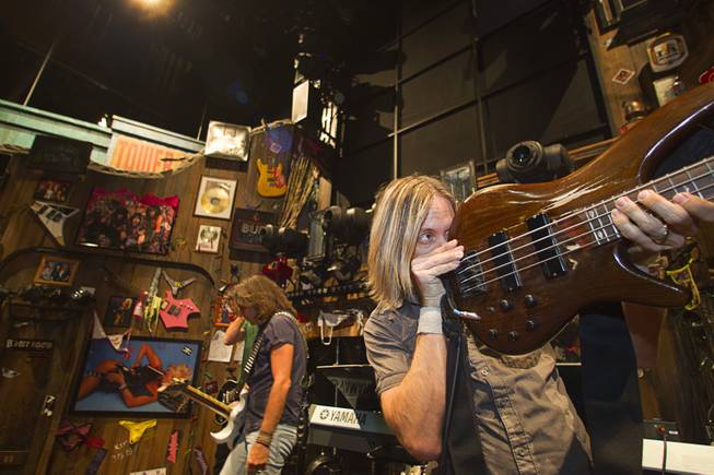 Guitarists and bassist Dan Grennes, right, prepare for a performance of "Rock Of Ages" at the Venetian Wednesday, Aug. 27, 2014.