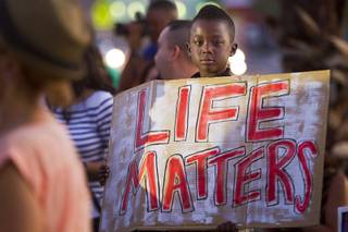 Derric Marshall, 7, holds a sign during a vigil for Michael Brown at Martin Luther King Boulevard and Carey Avenue Thursday, August 28, 2014. Brown, 18, was shot and killed by a police officer Aug. 9, 2014 in Ferguson, Mo.
