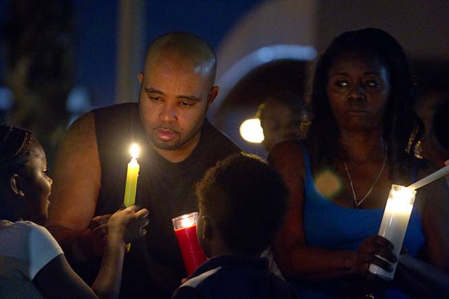 People light candles during a vigil for Michael Brown at Martin Luther King Boulevard and Carey Avenue Thursday, August 28, 2014. Brown, 18, was shot and killed by a police officer Aug. 9, 2014 in Ferguson, Mo.