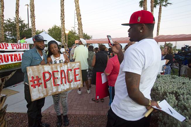L.A.F. Fletcher and Moneka Majors pose for Phillip Shelton during a vigil for Michael Brown at Martin Luther King Boulevard and Carey Avenue Thursday, August 28, 2014. Brown, 18, was shot and killed by a police officer Aug. 9, 2014 in Ferguson, Mo.