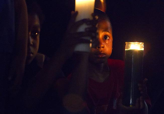 Lavel Burton, 5, holds a candle during a vigil for Michael Brown at Martin Luther King Boulevard and Carey Avenue Thursday, August 28, 2014. Brown, 18, was shot and killed by a police officer Aug. 9, 2014 in Ferguson, Mo.