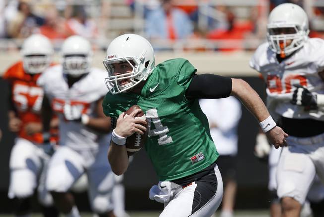 Oklahoma State quarterback J.W. Walsh (4) carries the ball during an Orange Blitz spring practice open to the public in Stillwater, Okla., Saturday, April 5, 2014. 