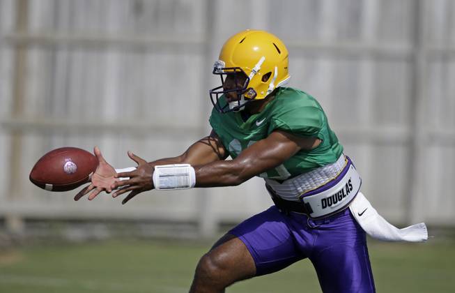 LSU quarterback Anthony Jennings (10) pitches out during their NCAA college football practice in Baton Rouge, La., Wednesday, Aug. 6, 2014. 