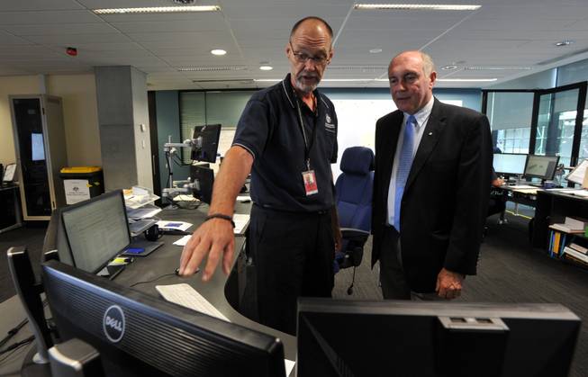 In this March 23, 2014, photo, Australian Deputy Prime Minister Warren Truss, right, talks with John Rice, senior search and rescue officer and mission coordinator for the search for the missing Malaysia Airlines Flight MH370, at rescue coordination center of the Australian Maritime Safety Authority in Canberra.
