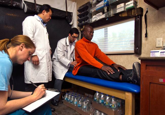 (From right) Patient Rene King has back examined resident Dr. Badi Eghterafi as faculty Dr. David Park oversees and student physician assistant Dode Cairncross takes notes within the Touro University Nevada Mobile Healthcare Clinic on Wednesday, August 27, 2014.