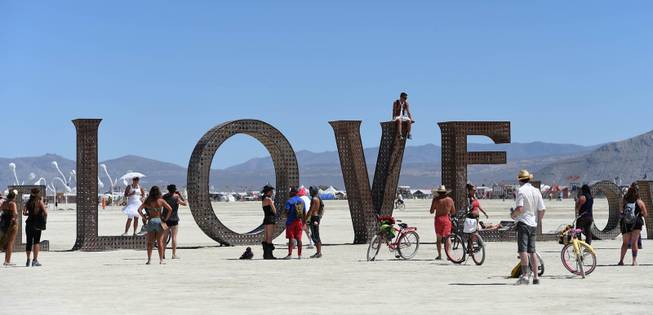 In this Aug. 27, 2014 photo, participants walk around at the Burning Man festival on the Black Rock Desert of Gerlach, Nev. Organizers call Burning Man the largest outdoor arts festival in North America, with its drum circles, decorated art cars, guerrilla theatrics and colorful theme camps. 