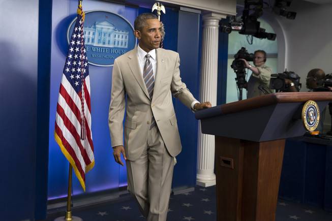 In this Thursday, Aug. 28, 2014, photo, President Barack Obama leaves after speaking about the economy, Iraq and Ukraine in the James Brady Press Briefing Room of The White House in Washington, D.C., before convening a meeting with his national security team on the militant threat in Syria and Iraq. Obama's summer fashion choice, not unprecedented among presidents — himself included — was the talk of social media Thursday. Other presidents who have taken on tan include Bill Clinton, Ronald Reagan, George H. W. Bush, George W. Bush and Dwight Eisenhower. 