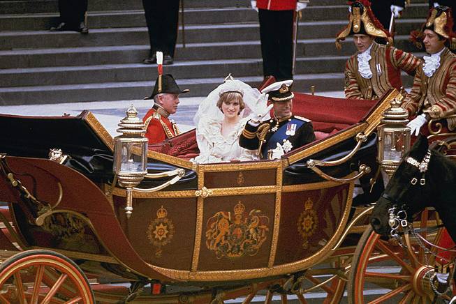 In this July 29, 1981, file photo, the carriage carrying the Prince and Princess of Wales passes along Trafalgar Square on its way from St. Paul's Cathedral to Buckingham Palace after the royal wedding in London. A 33-year-old slice of cake from Prince Charles and Princess Diana’s 1981 wedding has sold at auction for $1,375. 