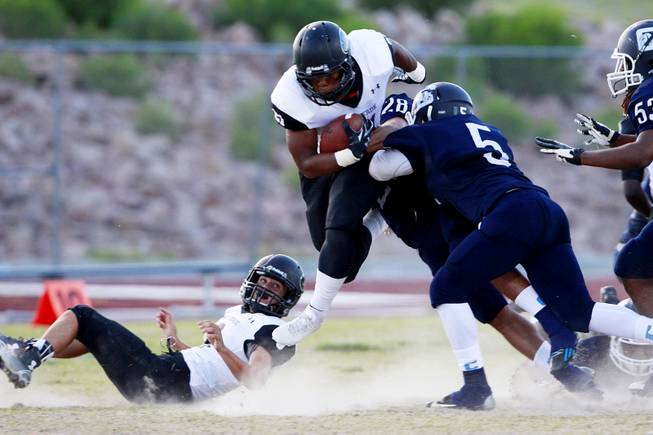 Centennial's Zach Mays gets taken down by Palo Verde's Christopher Johnson during their game Friday, Aug. 29, 2014 at Centennial.