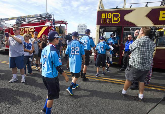 Players head to a double-decker, open-air Big Bus during a ceremony honoring the Mountain Ridge Little League team at Las Vegas City Hall Saturday, Aug. 30, 2014. After the ceremony, the team boarded an open-air Big Bus for a police-escorted parade down the Las vegas Strip.