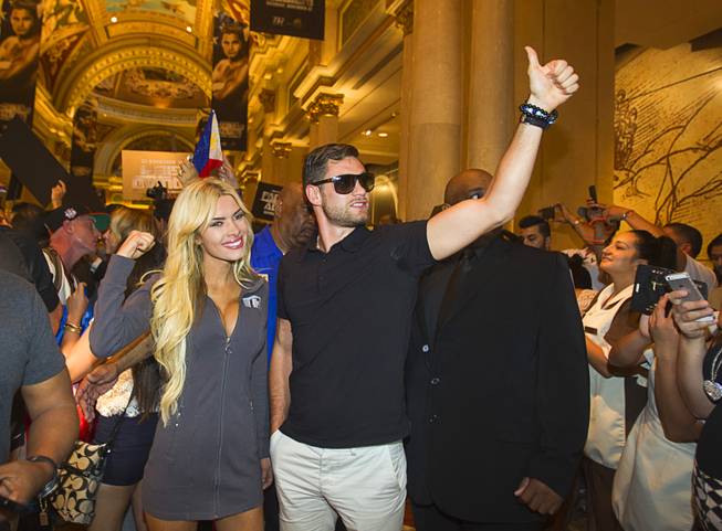Boxer Chris Algieri of Huntington, N.Y. gives a thumbs-up as he arrives at the Venetian Saturday, Aug. 30, 2014. Accompanying Algieri is Jessica Hubbard, a Top Rank Boxing Knockout girl. Algieri and Manny Pacquiao of the Philippines are on day six of an international tour promoting their WBO welterweight title fight in Macau, China on November 22, 2014.