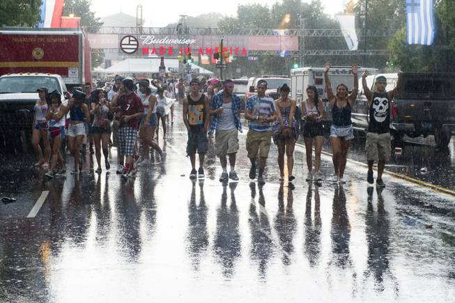 Concert goers leave the Made in America Festival after the grounds are evacuated due to thunderstorms on Sunday, Aug. 31, 2014, in Philadelphia.