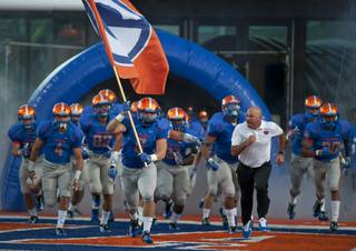 Bishop Gorman defensive end Ryan Garrett (5) leads head coach Tony Sanchez and the rest of the Gaels on to the field before the start of a game against Bingham Utah high school on Friday afternoon at Fertitta Field.