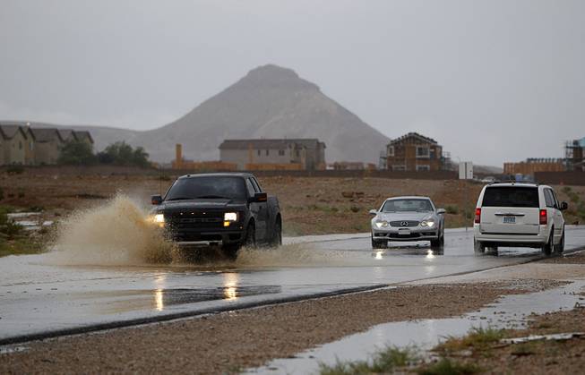A truck drives through storm runoff on Fort Apache Road. 