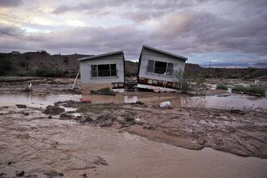 Receding floodwater surrounds a home in Moapa, Monday, Sept. 8, 2014. Flooding throughout the area damaged homes and roads. 