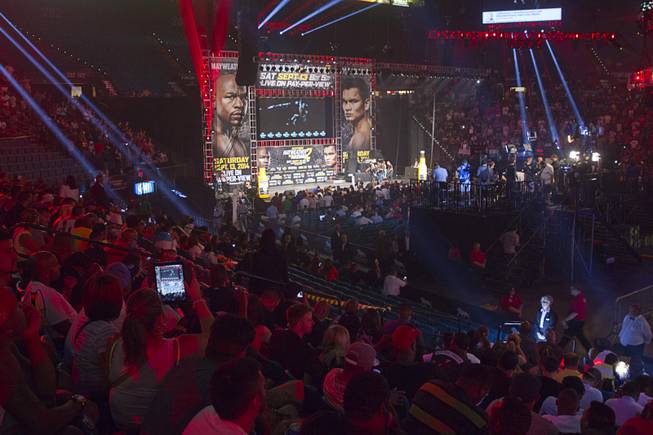 An estimated 8,000 fans pack MGM Grand Garden Arena as they wait for an official weigh-in for WBC/WBA welterweight champion Floyd Mayweather Jr. and Marcos Maidana in Las Vegas on Friday, Sept. 12, 2014. Mayweather Jr. will defend his titles against Maidana at the arena on Saturday.