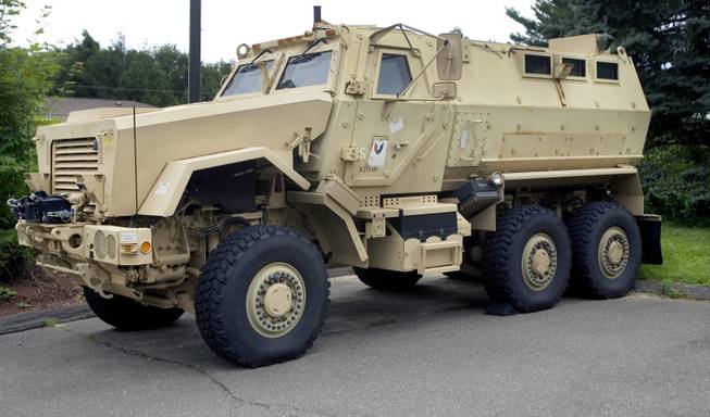 In this July 16, 2014, photo, a mine-resistant, ambush-protected vehicle sits in front of police headquarters in Watertown, Conn. The L.A. Unified School District's Police Department received a vehicle like this one through a federal program. School Police Departments across the country have taken advantage of free military surplus gear, stocking up on mine-resistant vehicles, grenade launchers and M16 rifles. At least 26 school districts across the country participate in the Pentagon’s surplus program, which has come under scrutiny after a militarized police response to protests in Ferguson, Mo.