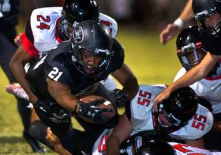 Palo Verde running back Jaren Campbell #21 dives for a touchdown while being taken down by Las Vegas defenders on Friday, September 19, 2014.