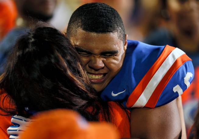 Bishop Gorman's Haskell Garrett #16 is hugged on the sidelines in congratulations after their 34-31 win over St. John Bosco on Friday, September 26, 2014.