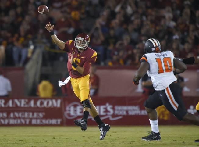 Southern California quarterback Cody Kessler, left, passes under pressure from Oregon State defensive tackle Jalen Grimble during the first half of an NCAA football game Saturday, Sept. 27, 2014, in Los Angeles.