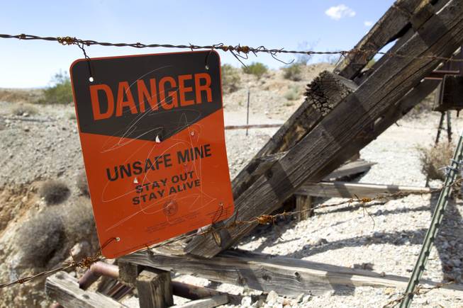 An "unsafe mine" sign is posted by an abandoned mine near Highway 95 is shown in Searchlight, Nev. Sunday Sept. 28, 2014. 