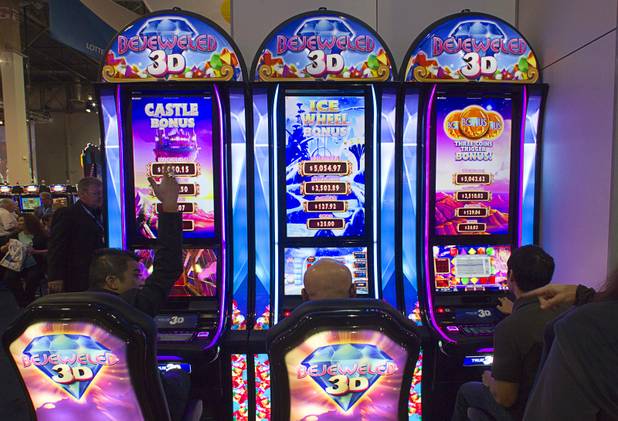 People try out Bejeweled True 3D slot machines in the GTECH booth during the final day of the Global Gaming Expo (G2E) at the Sands Expo Center Thursday, Oct. 2, 2014.