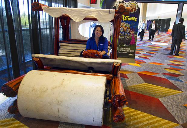 Mirabelle Chua of Hamden, Conn. tries out a "Flintstones" car during the Global Gaming Expo (G2E) at the Sands Expo Center Thursday, Oct. 2, 2014.