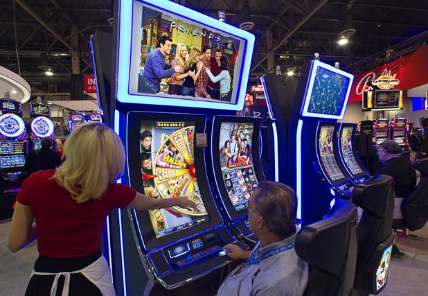 A man plays a "Friends" slot machine during the Global Gaming Expo (G2E) at the Sands Expo Center Thursday, Oct. 2, 2014.