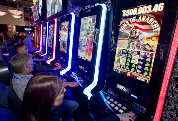 People play "Sons of Anarchy" slots machines at an Aristocrat booth during the Global Gaming Expo (G2E) at the Sands Expo Center Thursday, Oct. 2, 2014. The slot machine is based on a series on the FX cable network.