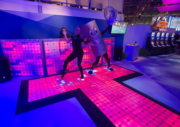 Sarah Romanowsky and a Quartermania costumed character pose in the IGT booth during the Global Gaming Expo (G2E) at the Sands Expo Center Thursday, Oct. 2, 2014.