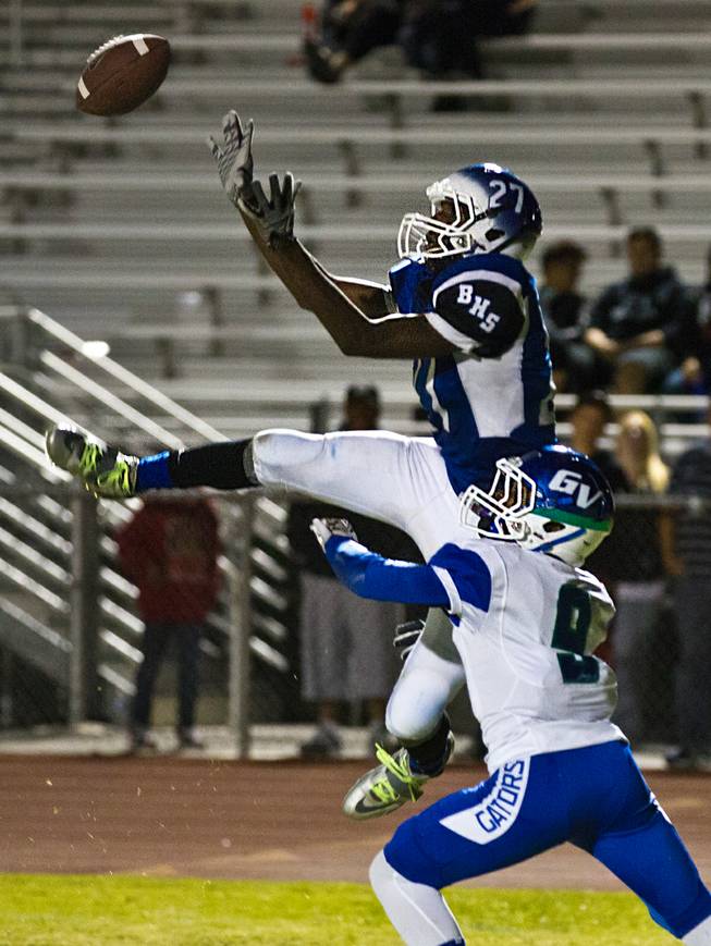 Basic High School's Josh Villaron #27 goes up high after a pass over Green Valley's Nazhi Salih #9 during the Henderson Bowl on Wednesday, October 2, 2014.