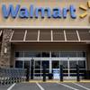 In this May 9, 2013, file photo, a worker pushes shopping carts in front of a Wal-Mart store in La Habra, Calif.