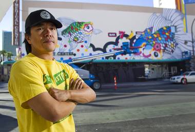 Artist Sush Machida poses by a mural he is creating with fellow artist Tim Bavington on the side of the Emergency Arts building at Fremont and Sixth streets in downtown Las Vegas Sunday, Oct. 12, 2014.